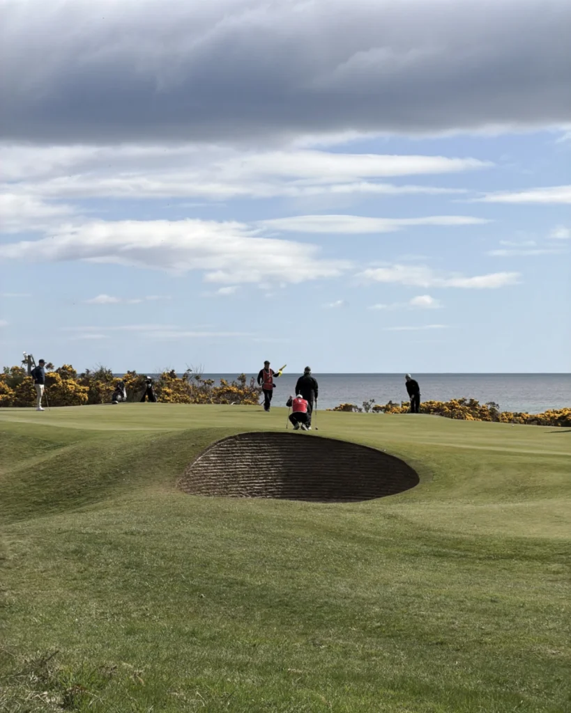 Golfers on a green overlooking the sea at Royal Dornoch Championship Course