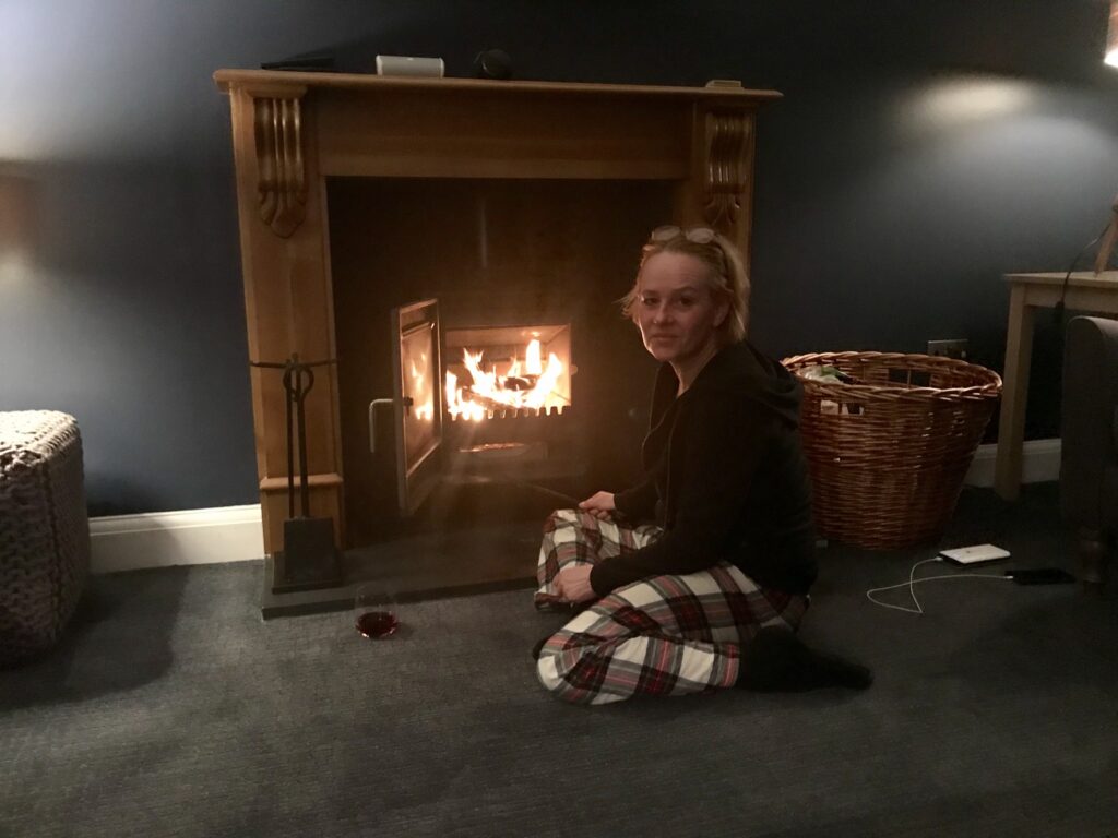 Woman in front of a fireplace at Burnside rental home in Dornoch